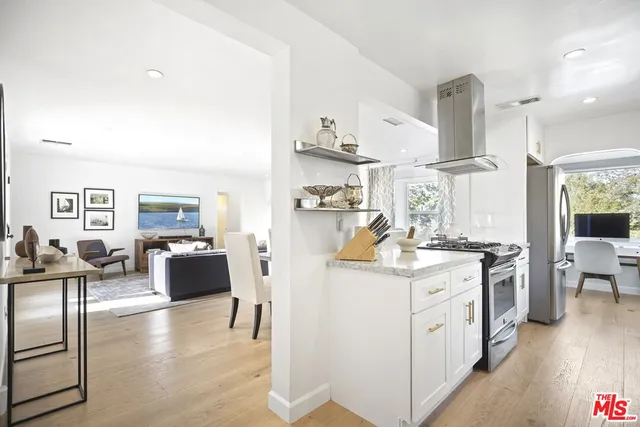 a kitchen with stainless steel appliances a sink a stove and a microwave