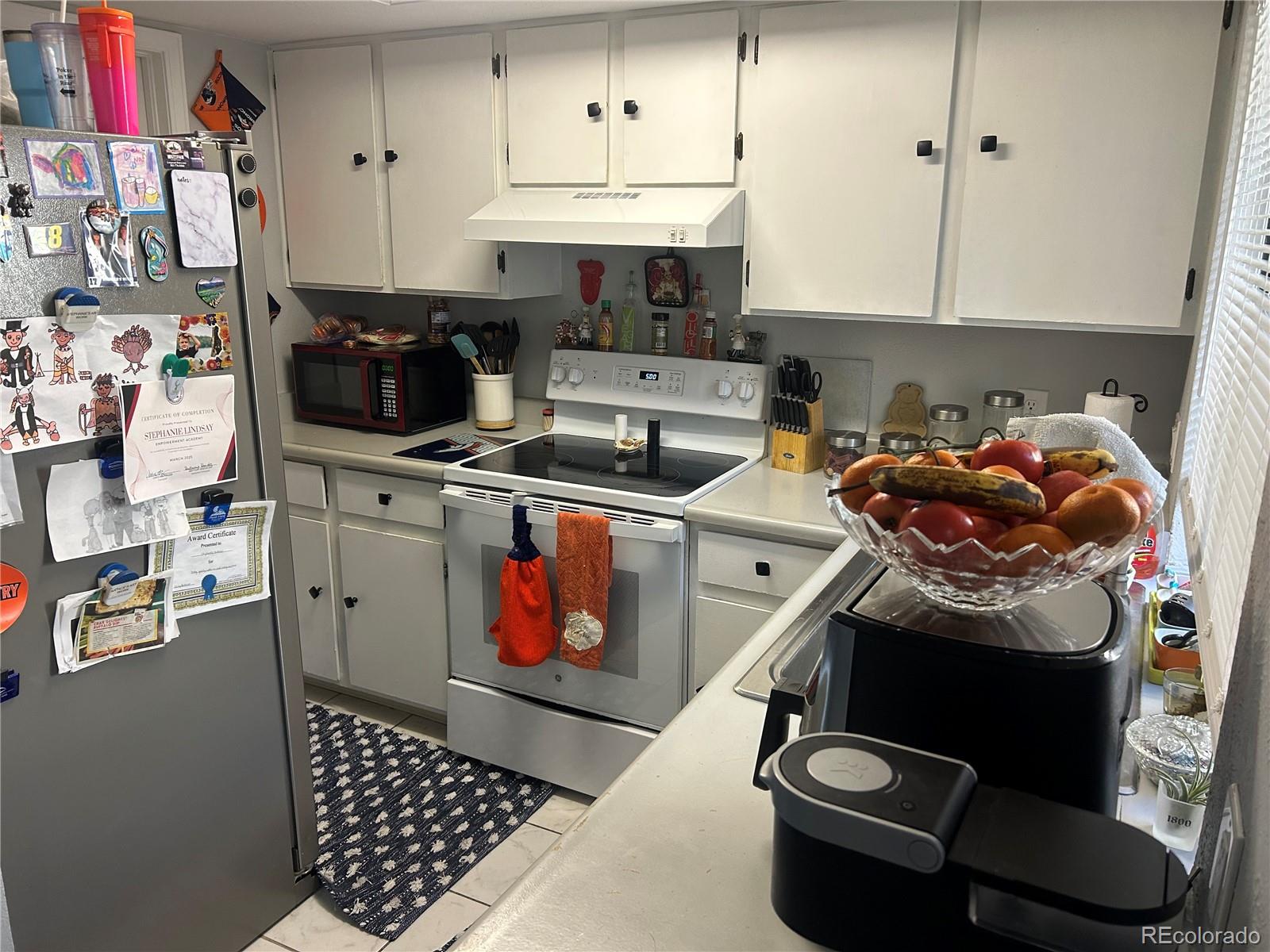 7980 Chase Circle, Unit F Arvada, CO 80003 - Photo 6 of 16 a kitchen with stainless steel appliances kitchen island granite countertop a sink stove and cabinets