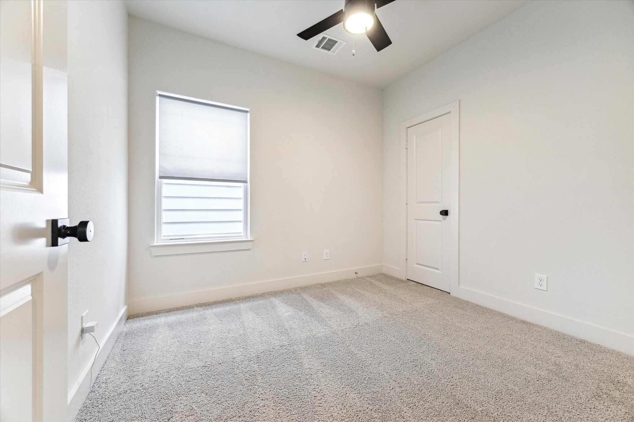 4155 Griggs Road Houston, TX 77021 - Photo 14 of 17 Secondary bedroom with plush neutral carpet, sleek black ceiling fan, bright natural light, and roomy walk-in closet.