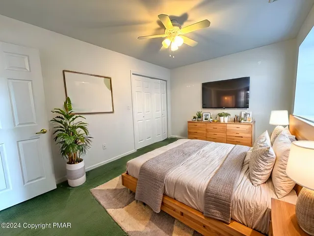 an empty room with a chandelier fan and windows