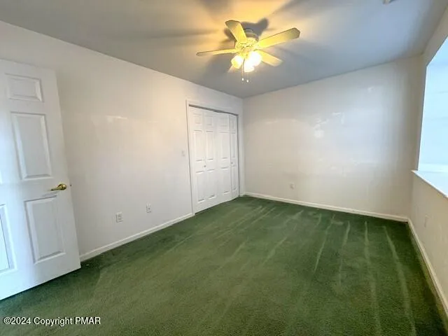 an empty room with a ceiling fan and a window