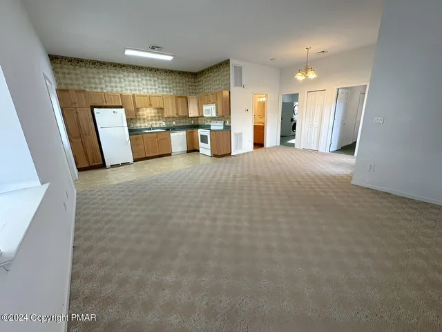 a dining room with furniture a chandelier and wooden floor