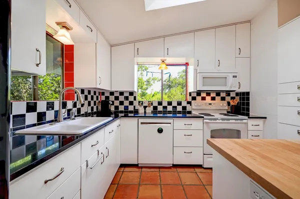 a kitchen with granite countertop a sink stainless steel appliances and cabinets
