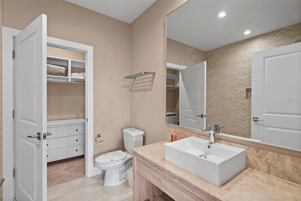 3099 Rockefeller Way Kissimmee, FL 34747 - Photo 29 of 54 a bathroom with a sink a toilet and a large mirror