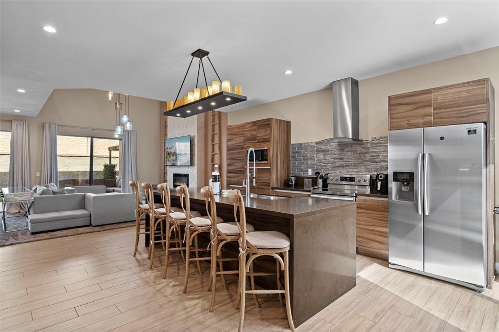 3099 Rockefeller Way Kissimmee, FL 34747 - Photo 3 of 54 a kitchen with stainless steel appliances a table chairs refrigerator and cabinets
