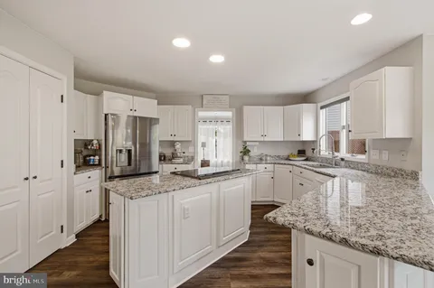 a kitchen with stainless steel appliances granite countertop a stove a sink and a refrigerator
