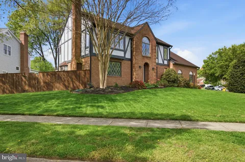 a front view of a house with a garden and trees