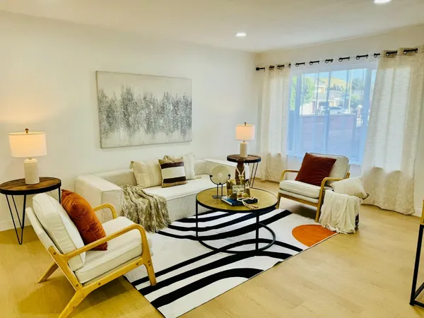 a living room with furniture and a wooden floor