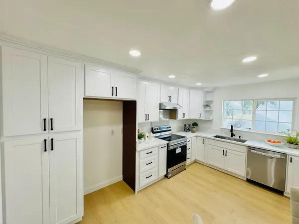 a kitchen with a sink a stove a refrigerator and cabinets