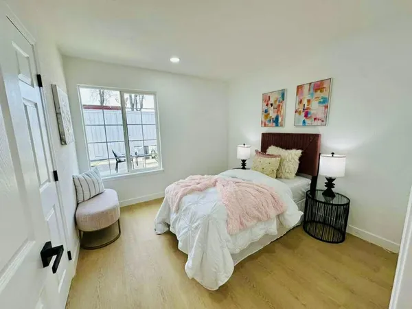 a bedroom with a bed and a large window