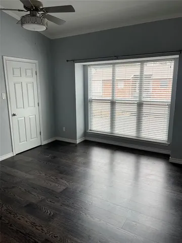 a view of a livingroom with wooden floor and a window