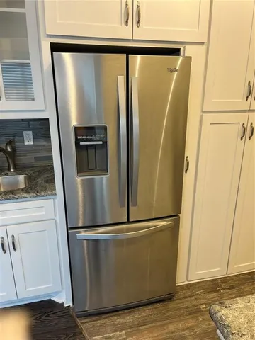 a view of a refrigerator in kitchen and wooden floor