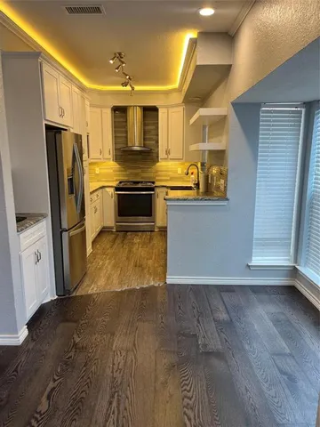 a kitchen with granite countertop a refrigerator and a sink