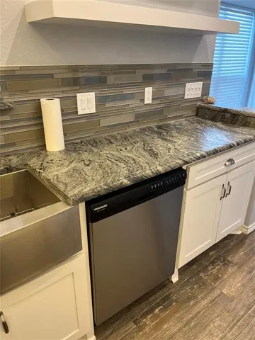a kitchen with granite countertop a sink and a stove