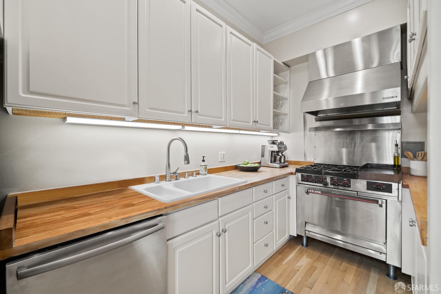 1 Cottage Row San Francisco, CA 94115 - Photo 22 of 52 a kitchen with granite countertop white cabinets and white appliances
