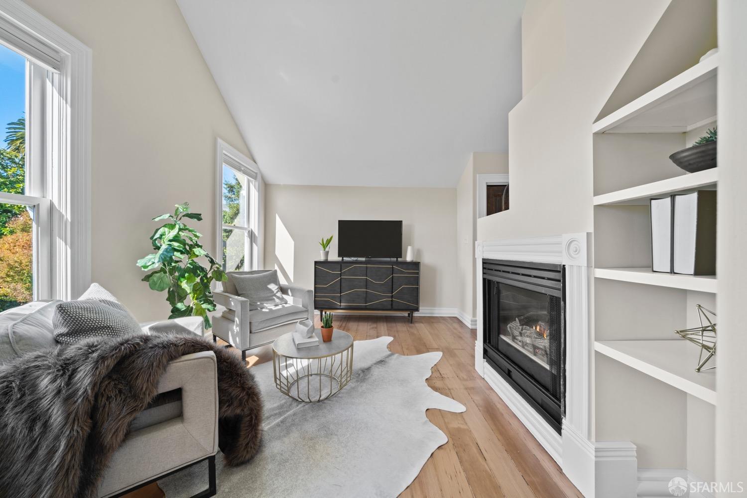 1 Cottage Row San Francisco, CA 94115 - Photo 6 of 52 a bedroom with a bed a fireplace and a flat tv screen