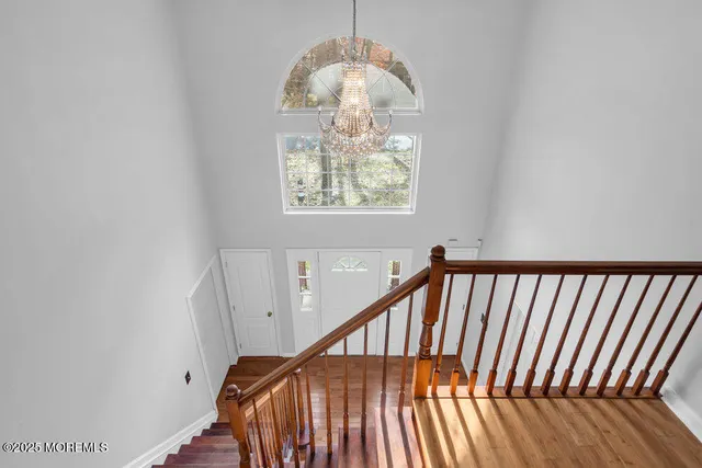 a view of staircase with railing and a chandelier