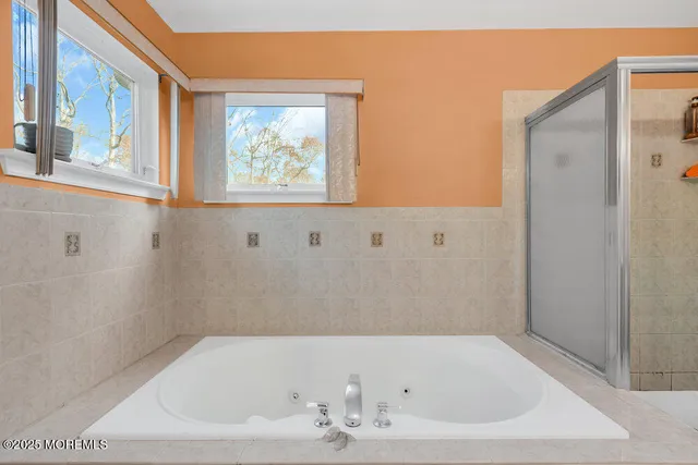 a bathroom with bathtub and window