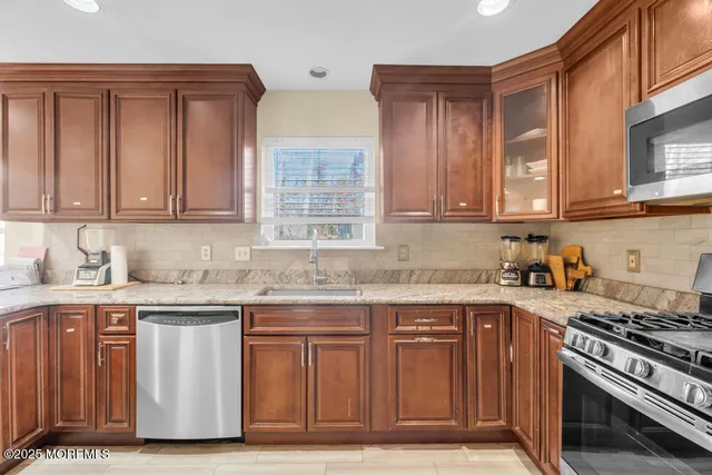 a kitchen with granite countertop wooden cabinets and a stove top oven