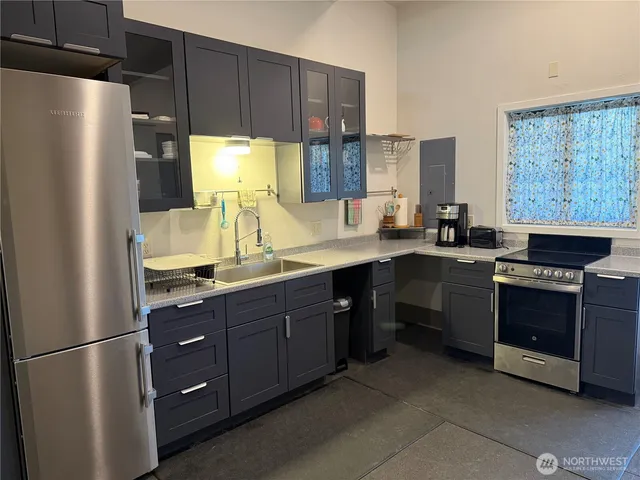 a kitchen with a sink a stove a refrigerator and a window