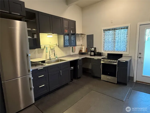 a view of a kitchen with fridge and wooden floor