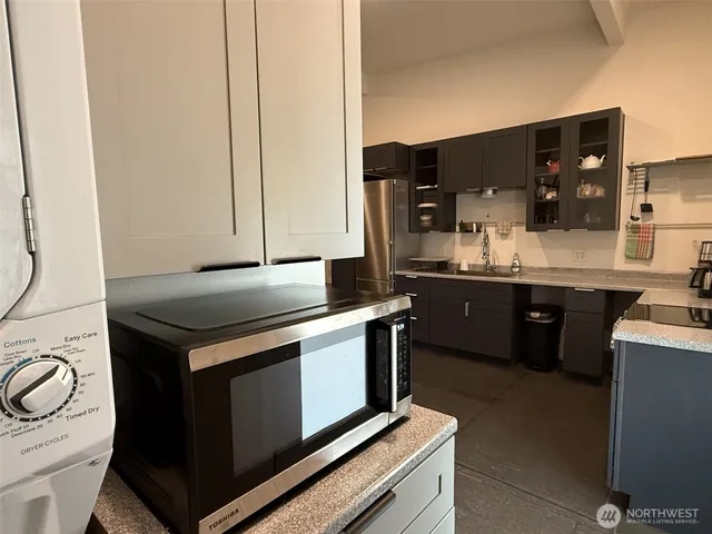 a kitchen with stainless steel appliances a dining table chairs and refrigerator