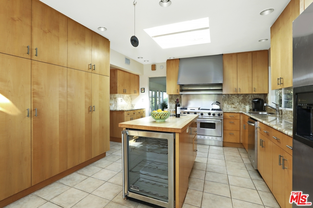 1629 Tower Grove Drive Beverly Hills, CA 90210 - Photo 13 of 29 a kitchen with stainless steel appliances granite countertop a stove a sink and a refrigerator