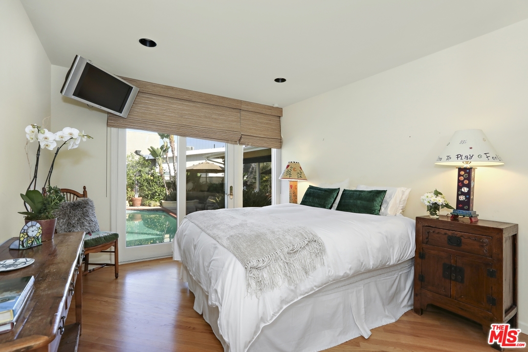 1629 Tower Grove Drive Beverly Hills, CA 90210 - Photo 16 of 29 a bedroom with a large bed and a flat tv screen on dresser