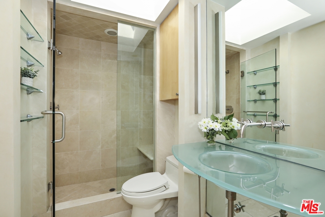 1629 Tower Grove Drive Beverly Hills, CA 90210 - Photo 17 of 29 a bathroom with a granite countertop sink toilet and shower