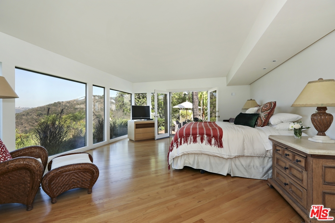 1629 Tower Grove Drive Beverly Hills, CA 90210 - Photo 19 of 29 a bedroom with furniture and a large window
