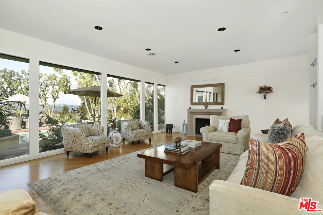 1629 Tower Grove Drive Beverly Hills, CA 90210 - Photo 4 of 29 a living room with fireplace furniture and a large window