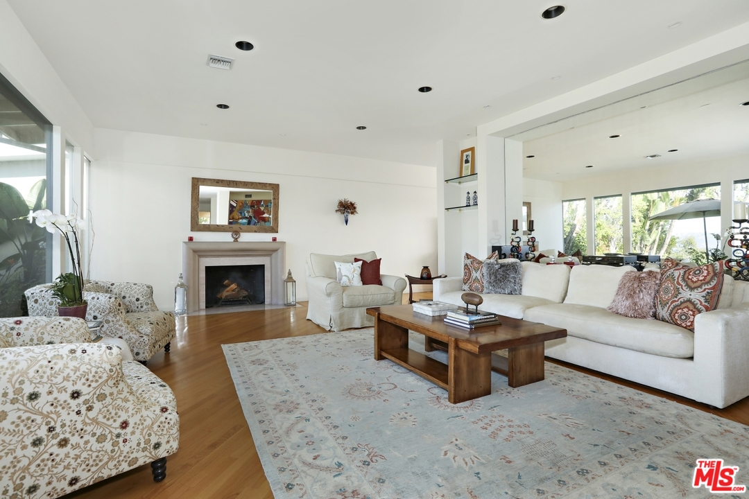 1629 Tower Grove Drive Beverly Hills, CA 90210 - Photo 5 of 29 a living room with furniture a fireplace and a table