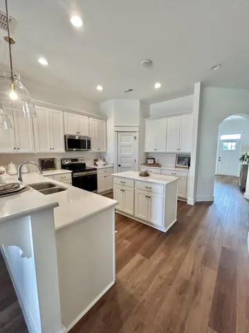 a kitchen with kitchen island a white counter top space cabinets and stainless steel appliances