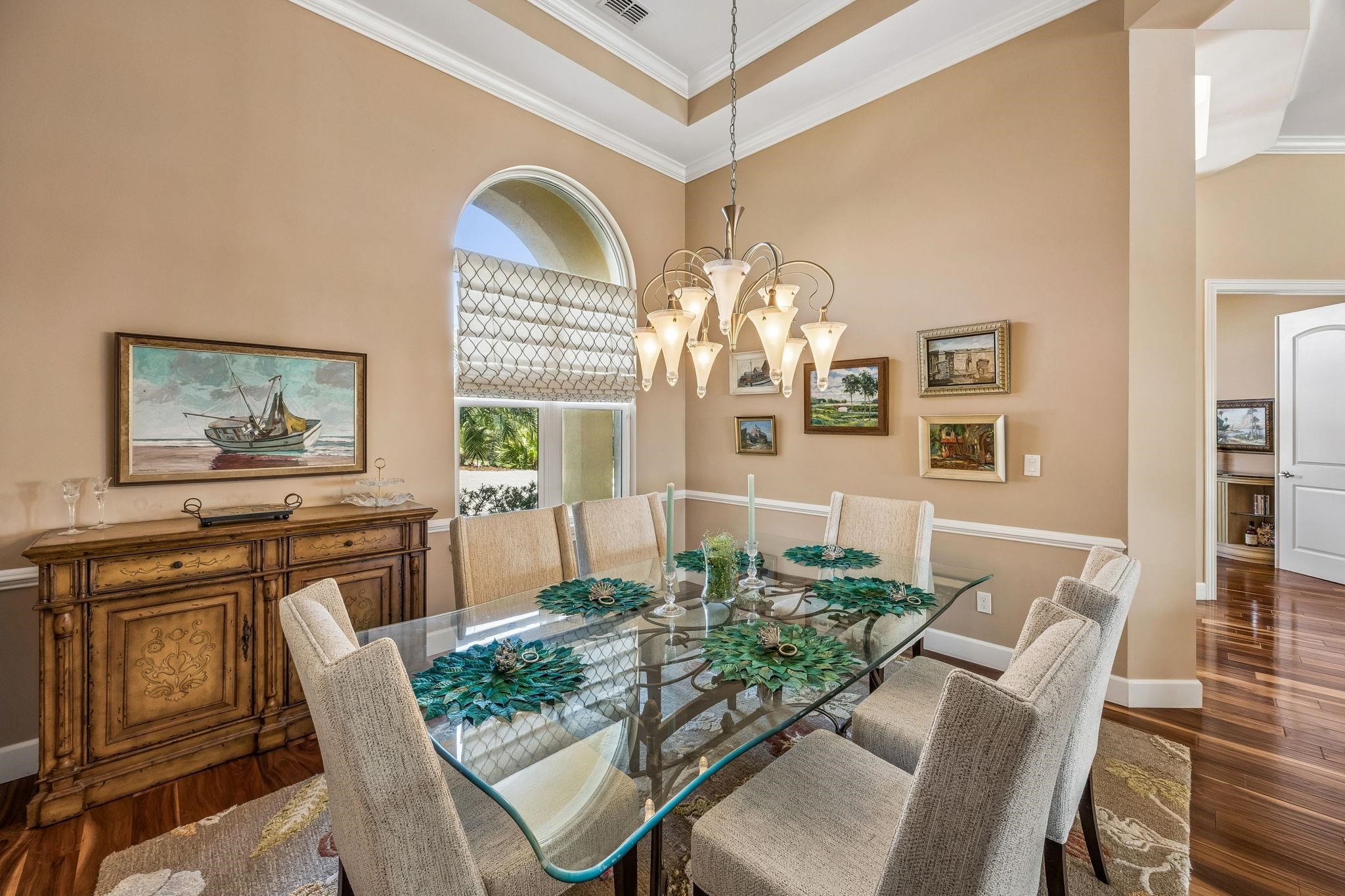 409 Lookout Point Drive St. Augustine, FL 32080 - Photo 13 of 90 Dining space featuring dark wood-type flooring, crown molding, hanging lights, and a high ceiling