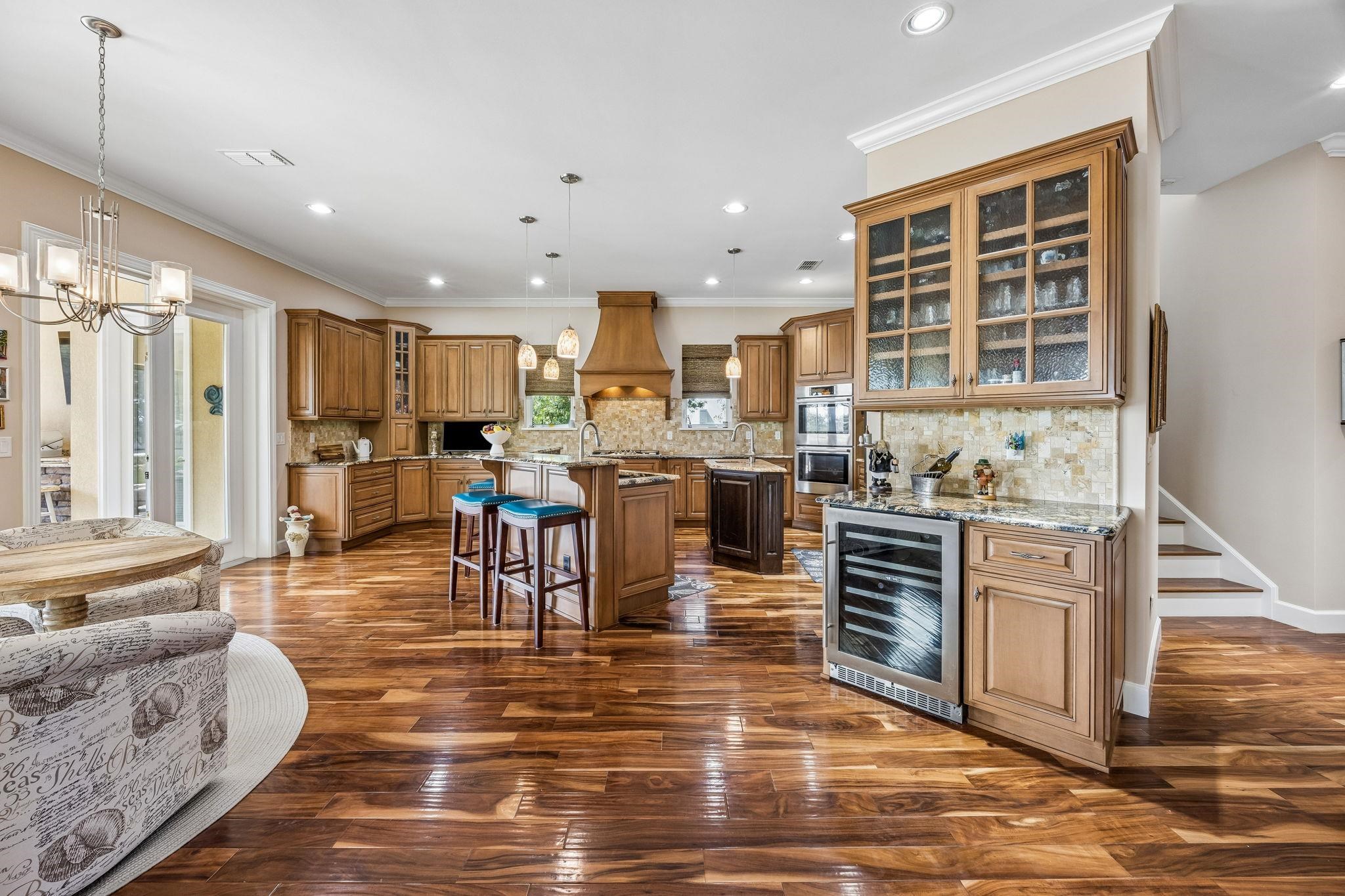 409 Lookout Point Drive St. Augustine, FL 32080 - Photo 23 of 90 a kitchen with stainless steel appliances granite countertop a stove top oven a sink dishwasher a dining table and chairs with wooden floor