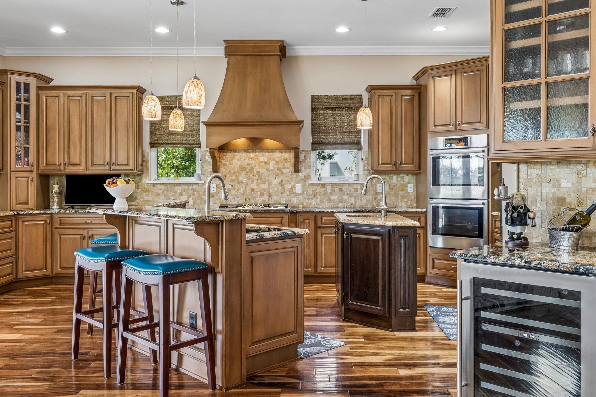 409 Lookout Point Drive St. Augustine, FL 32080 - Photo 25 of 90 Kitchen with glass insert cabinets, a kitchen island with sink, wine cooler, wood finish cabinetry, and crown molding