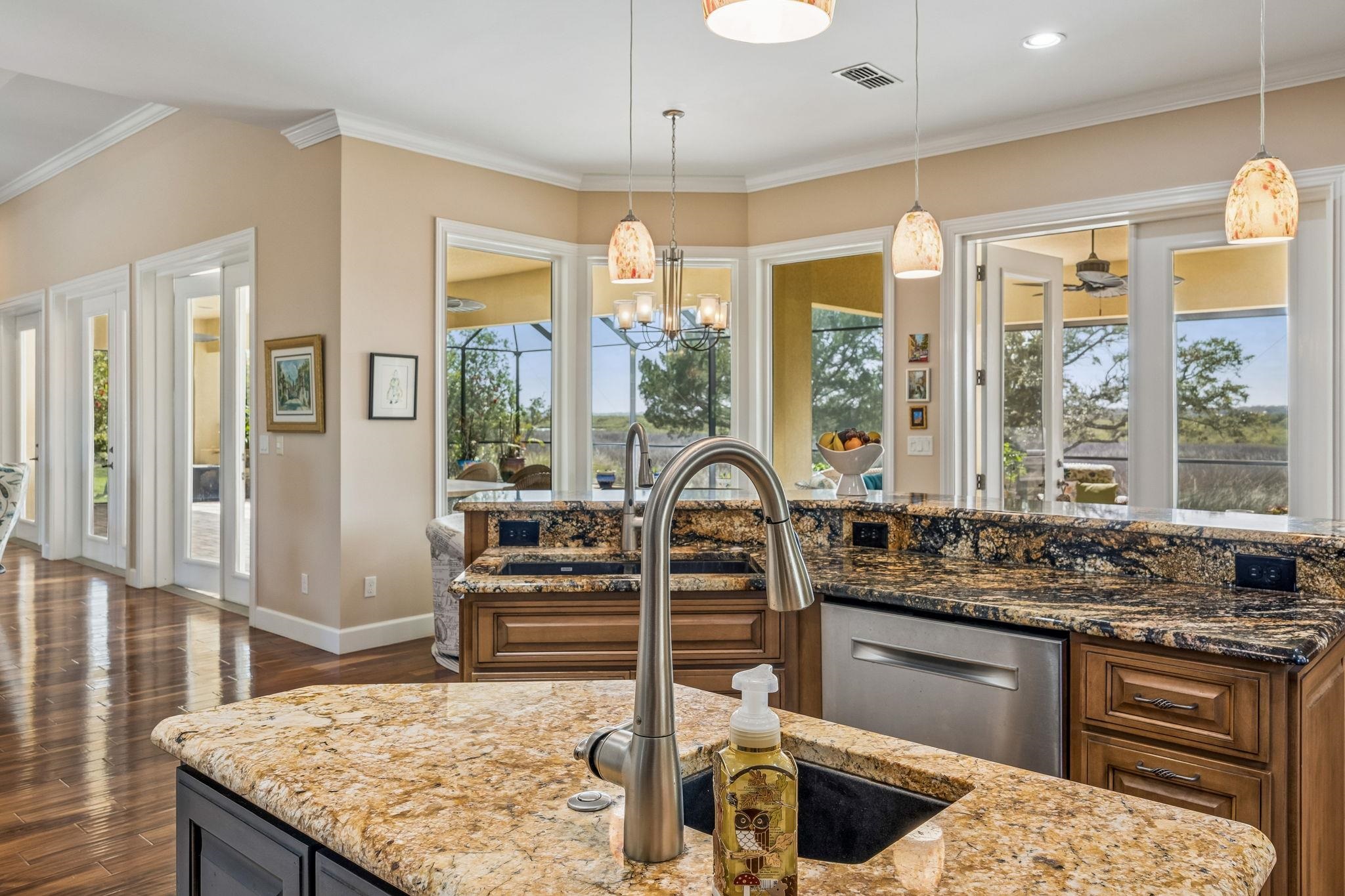 409 Lookout Point Drive St. Augustine, FL 32080 - Photo 26 of 90 Kitchen featuring dark stone countertops, healthy amount of natural light, crown molding, and a chandelier
