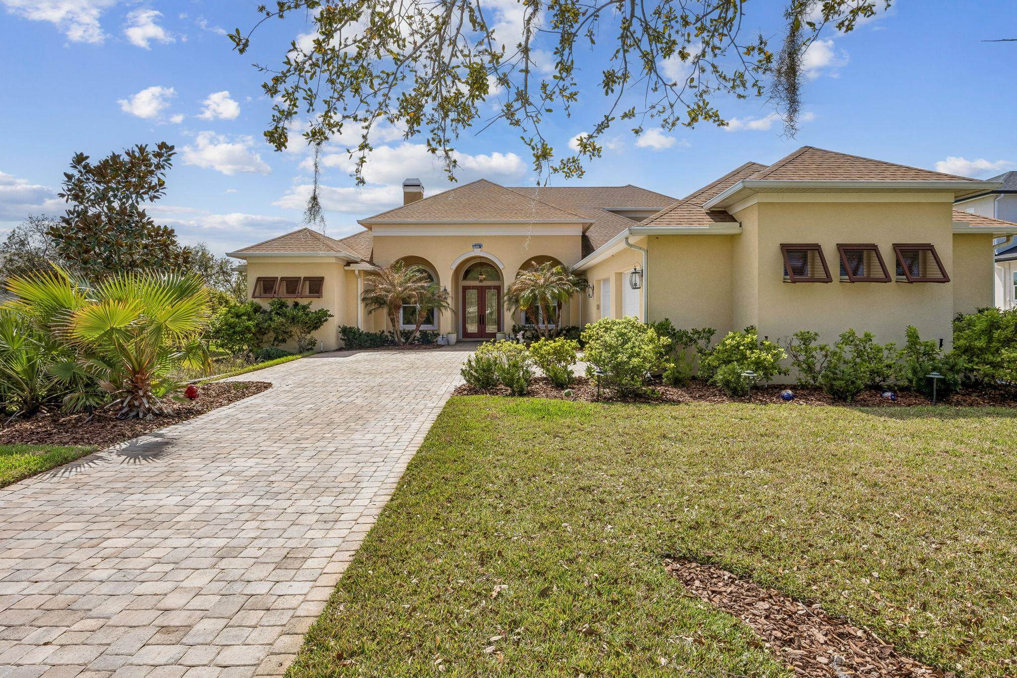 409 Lookout Point Drive St. Augustine, FL 32080 - Photo 3 of 90 Mediterranean / spanish-style house with stucco siding, a front lawn, decorative driveway, french doors, and a chimney