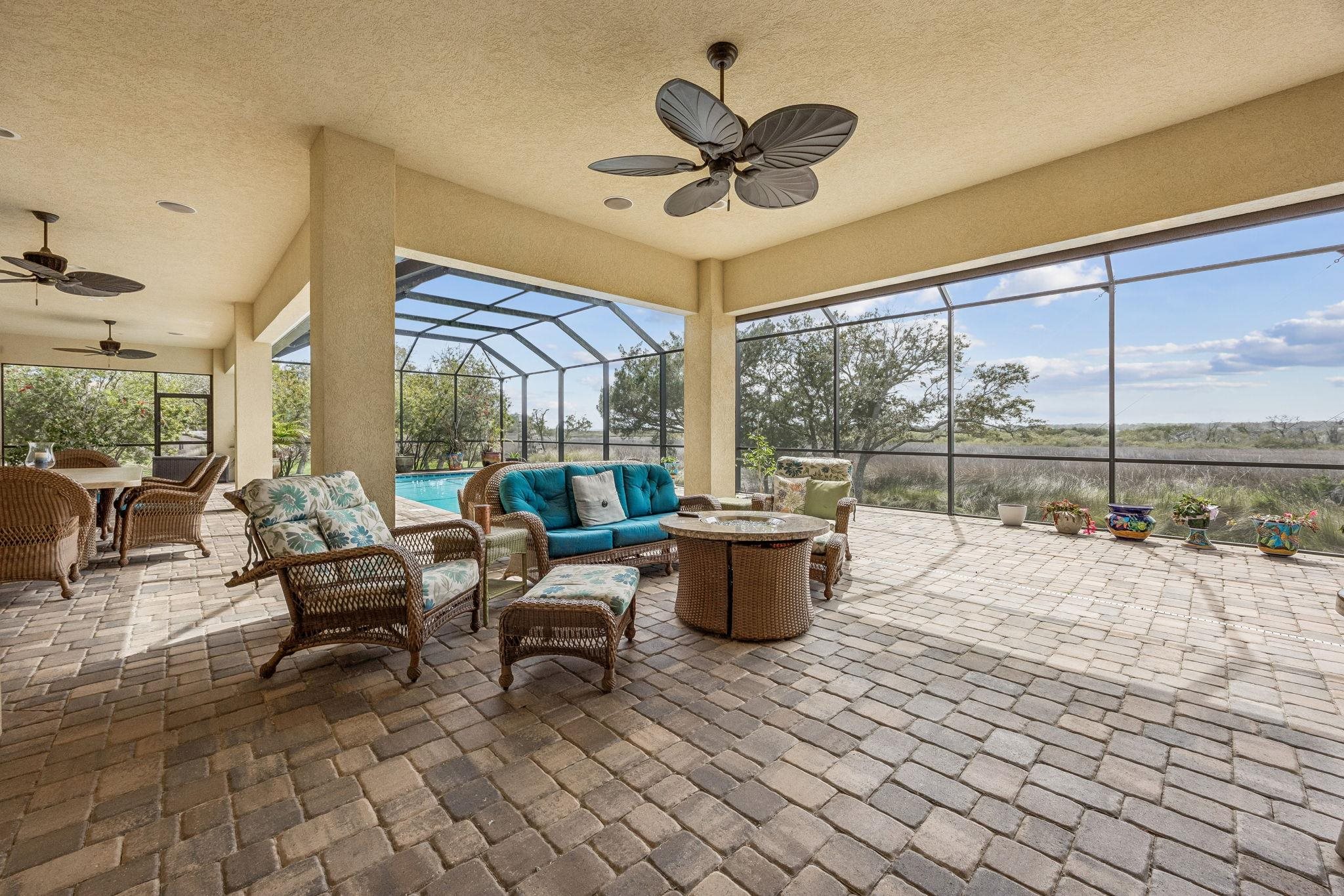409 Lookout Point Drive St. Augustine, FL 32080 - Photo 31 of 90 View of patio featuring a ceiling fan, glass enclosure, a sunroom, and an outdoor living / dining area