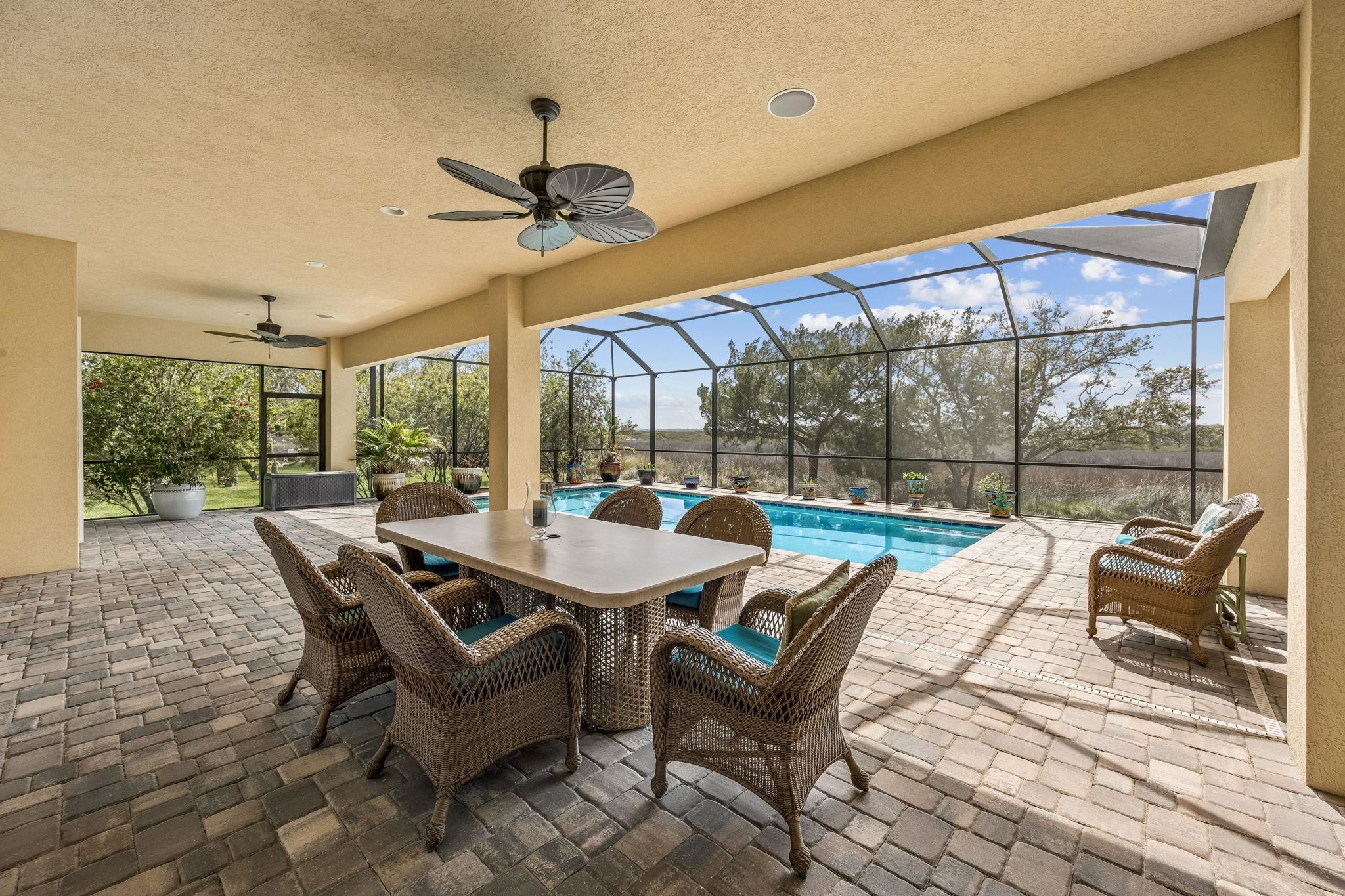 409 Lookout Point Drive St. Augustine, FL 32080 - Photo 33 of 90 View of patio / terrace featuring a ceiling fan, a sunroom, a lanai, outdoor dining space, and an outdoor pool