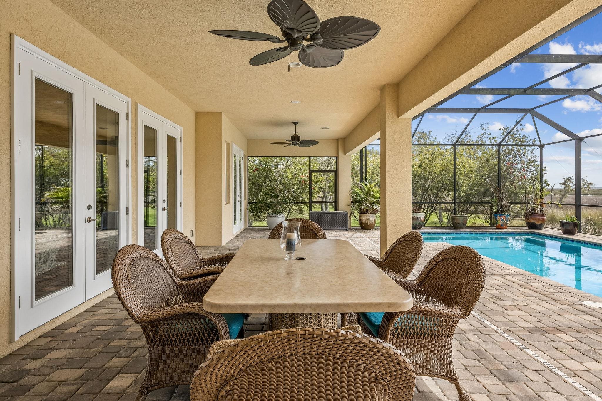 409 Lookout Point Drive St. Augustine, FL 32080 - Photo 34 of 90 View of patio with a sunroom, ceiling fan, outdoor dining space, a lanai, and an outdoor pool