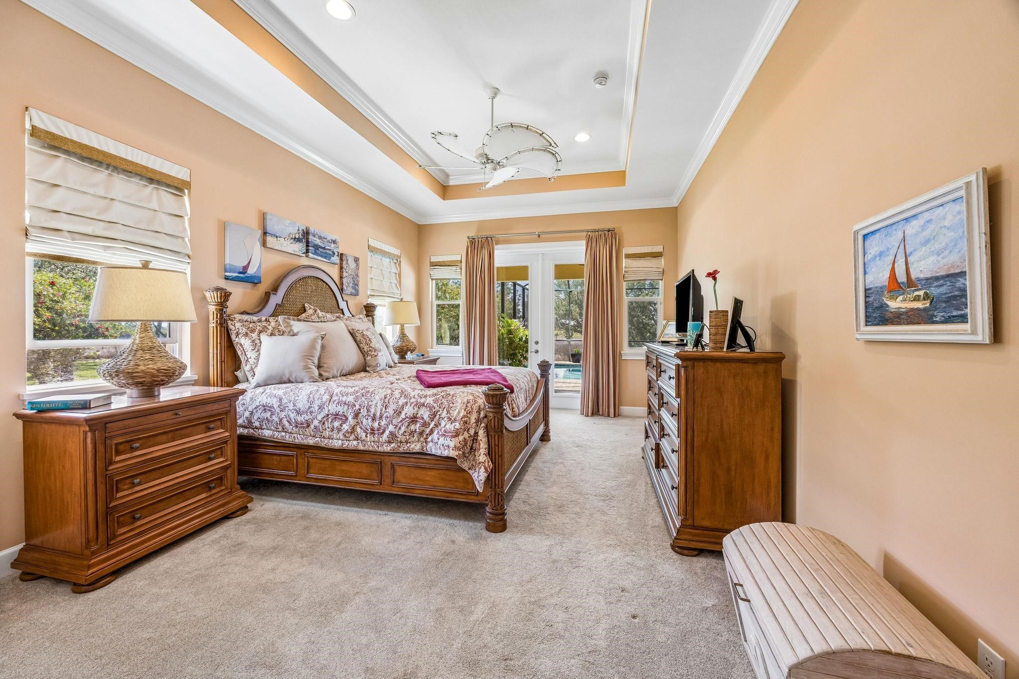 409 Lookout Point Drive St. Augustine, FL 32080 - Photo 45 of 90 Bedroom featuring french doors, crown molding, access to outside, light carpet, and a tray ceiling