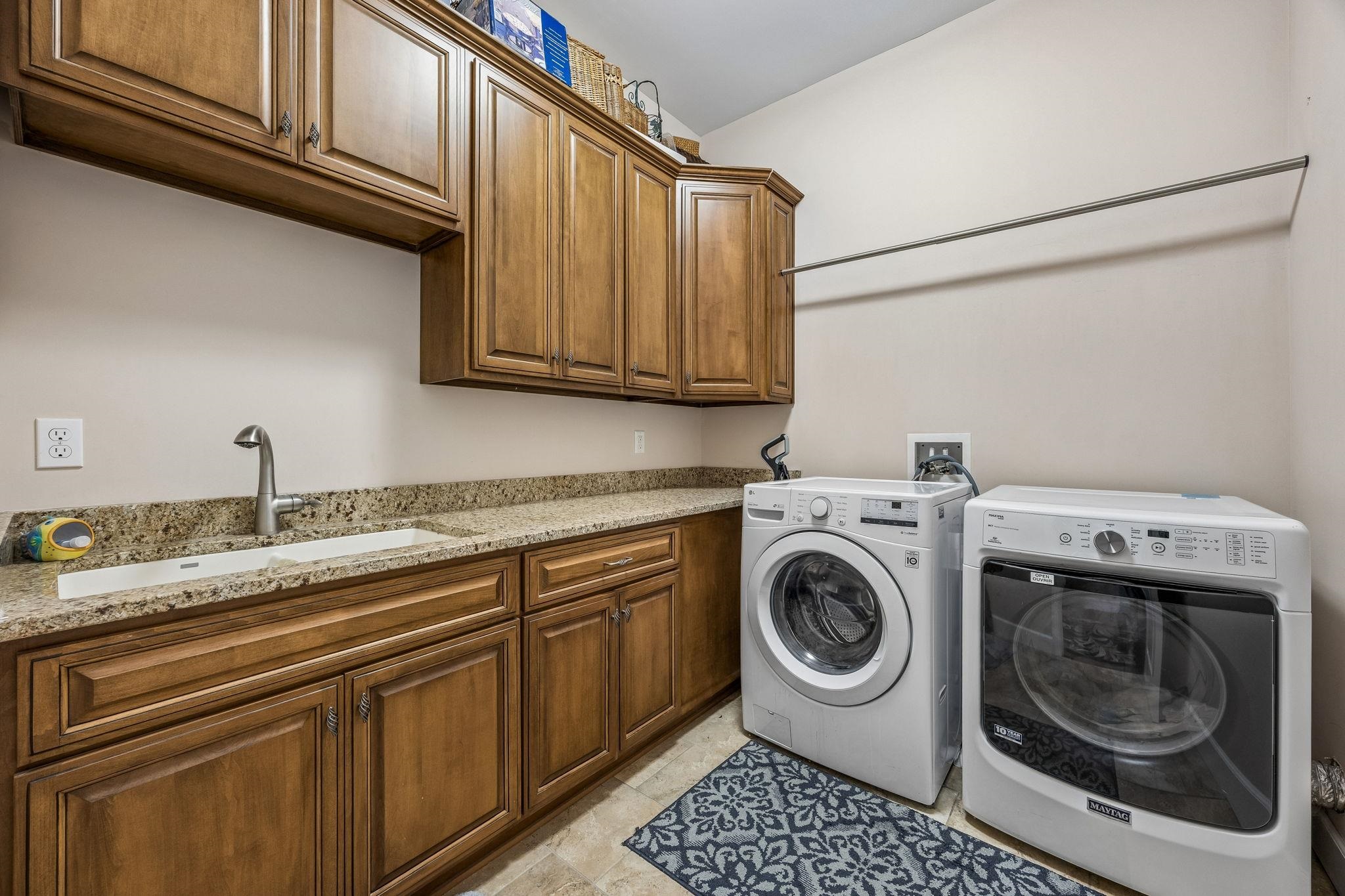 409 Lookout Point Drive St. Augustine, FL 32080 - Photo 76 of 90 Laundry area featuring washer and clothes dryer, cabinet space, and light tile patterned floors