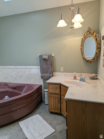 1040 West Mill Road Ferron, UT 84523 - Photo 34 of 117 Corner soaking tub, dual-tone vanity with integrated sink, stone-finish countertop, and brushed nickel light fixture