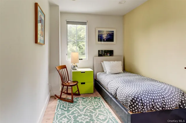 a bedroom with a bed a window and chair