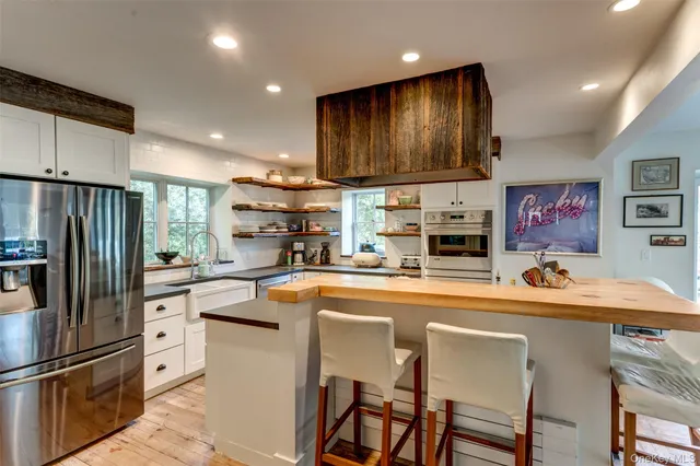 a kitchen with stainless steel appliances granite countertop a refrigerator and a stove top oven