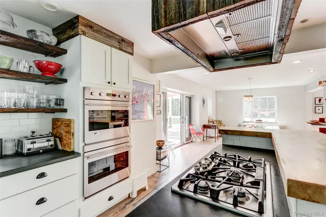 a kitchen with stainless steel appliances kitchen island granite countertop a stove and a sink