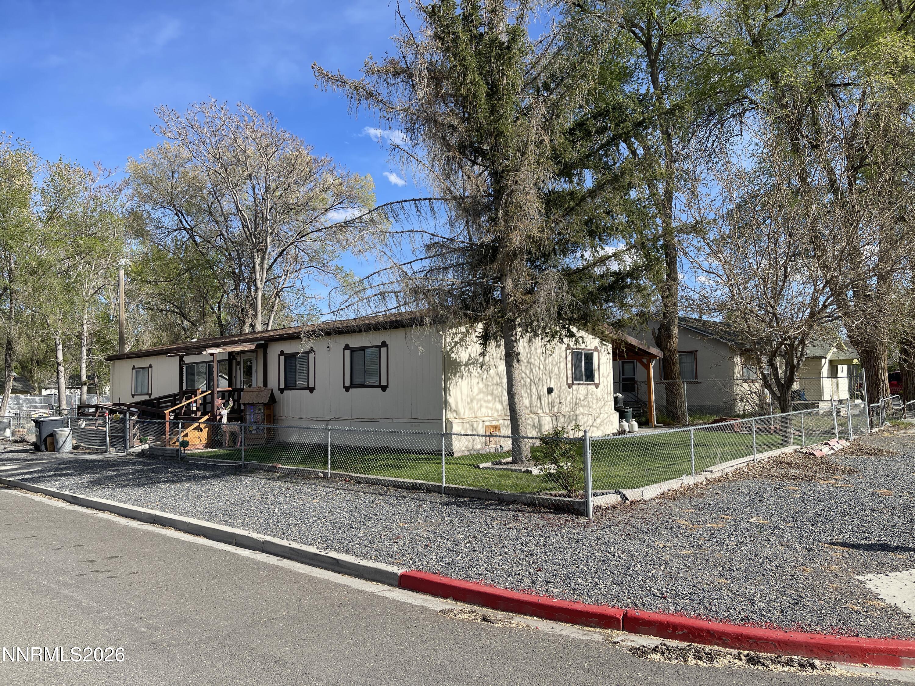 a view of a house with a yard and large tree