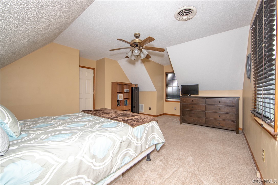 15803 Loving Union Road Disputanta, VA 23842 - Photo 28 of 39 a spacious bedroom with a bed and a chandelier