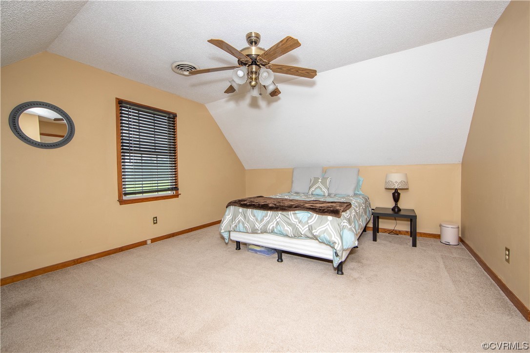 15803 Loving Union Road Disputanta, VA 23842 - Photo 29 of 39 a bedroom with a bed and a chandelier